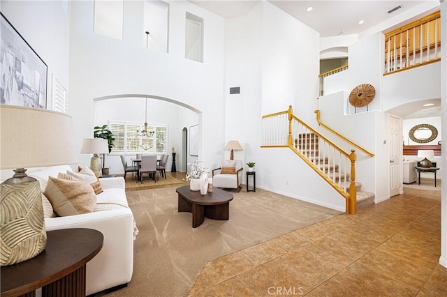 42355 Mountain View Ct, Murrieta, CA 92562 - living area with arched walkways, a high ceiling, stairs, tile patterned flooring, and carpet