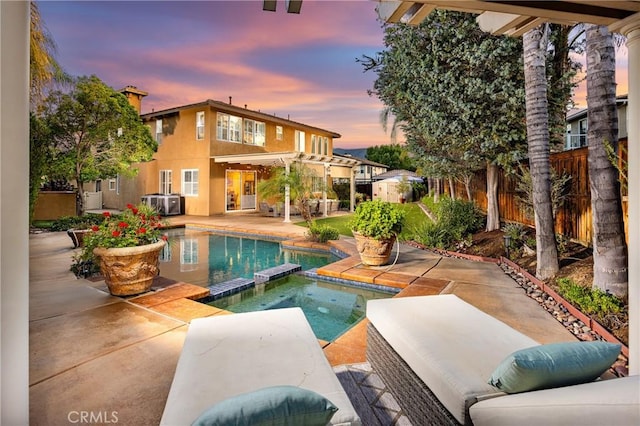 42355 Mountain View Ct, Murrieta, CA 92562 - pool at dusk with a patio area, a pool with connected hot tub, a fenced backyard, and an outdoor structure