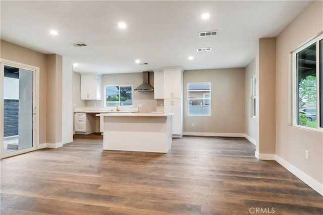 3067 Genevieve St, San Bernardino, CA 92405 - kitchen featuring wall chimney exhaust hood, a center island, white cabinets, light countertops, and recessed lighting