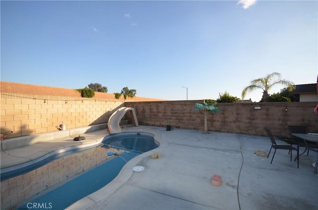 27958 Foxfire St, Menifee, CA 92586 - view of swimming pool with a water slide, a fenced backyard, and a patio area