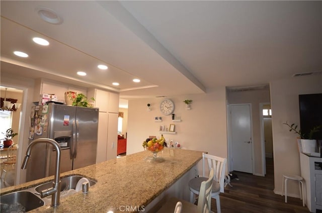 27958 Foxfire St, Menifee, CA 92586 - kitchen featuring stainless steel fridge with ice dispenser, a raised ceiling, recessed lighting, dark wood-style floors, and light stone counters