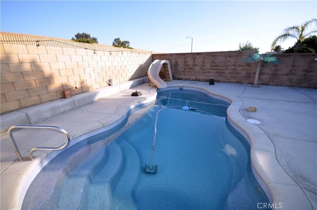 27958 Foxfire St, Menifee, CA 92586 - view of swimming pool with a water slide, a fenced backyard, and a patio