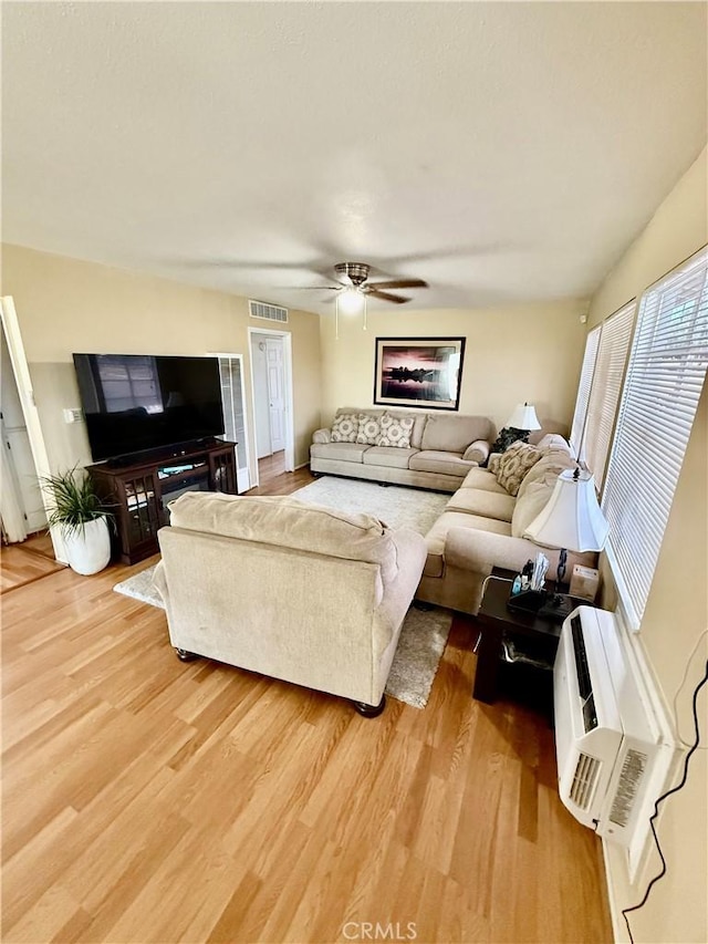 2616 N King St, Bakersfield, CA 93305 - living room with light wood finished floors, ceiling fan, and an AC wall unit