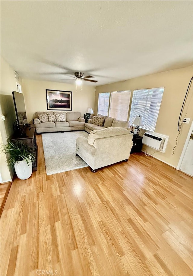 2616 N King St, Bakersfield, CA 93305 - living area featuring a wall mounted AC, light wood finished floors, and a ceiling fan