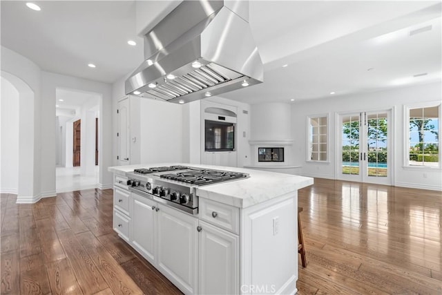 25471 Prado De Oro, Calabasas, CA 91302 - kitchen featuring exhaust hood, stainless steel gas cooktop, arched walkways, open floor plan, and a kitchen island