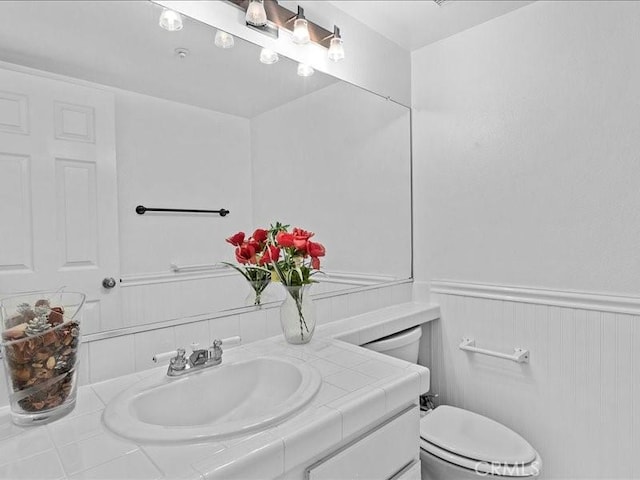 19025 Windridge Ln, Huntington Beach, CA 92646 - half bath featuring vanity, wainscoting, and a decorative wall