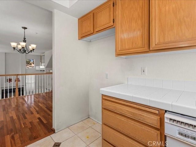 19025 Windridge Ln, Huntington Beach, CA 92646 - kitchen with a chandelier, brown cabinets, light tile patterned floors, decorative light fixtures, and dishwasher