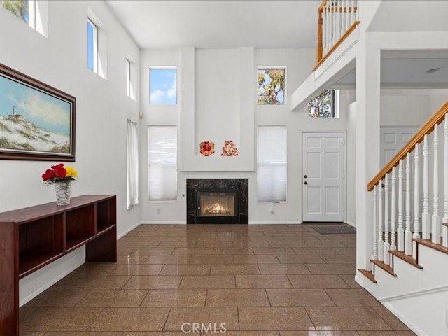 19025 Windridge Ln, Huntington Beach, CA 92646 - foyer with a towering ceiling, stairway, and a premium fireplace