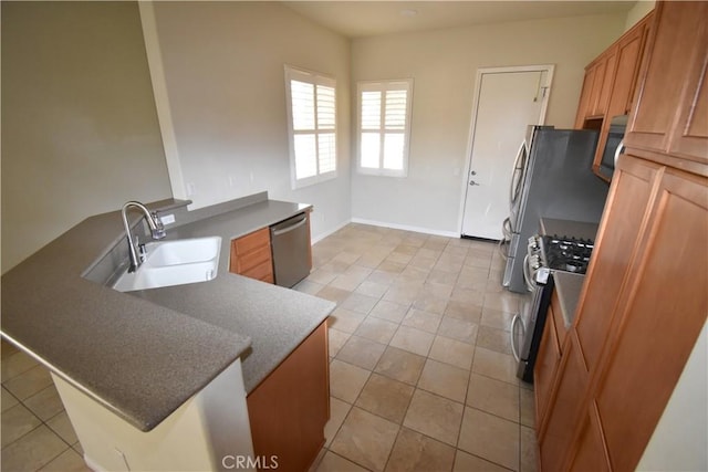 19485 Tor Hill Ln, Apple Valley, CA 92308 - kitchen with stainless steel appliances, light tile patterned floors, a peninsula, and brown cabinets