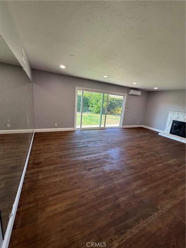 4561 Mimosa Dr, Yorba Linda, CA 92886 - unfurnished living room with an AC wall unit, a textured ceiling, dark wood-style floors, recessed lighting, and a stone fireplace