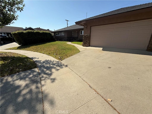 4561 Mimosa Dr, Yorba Linda, CA 92886 - view of property exterior with a yard, concrete driveway, an attached garage, and stone siding