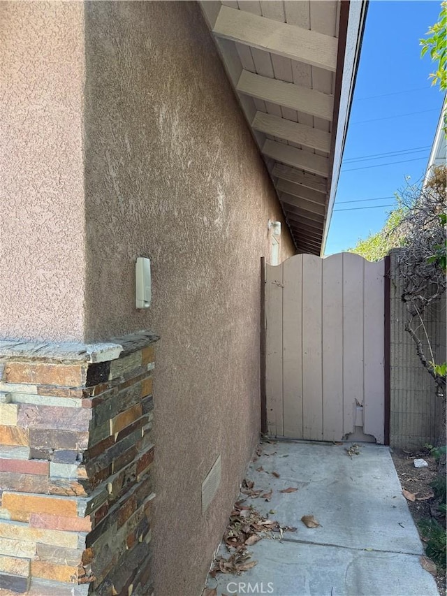 4561 Mimosa Dr, Yorba Linda, CA 92886 - view of property exterior featuring stucco siding, crawl space, and a gate