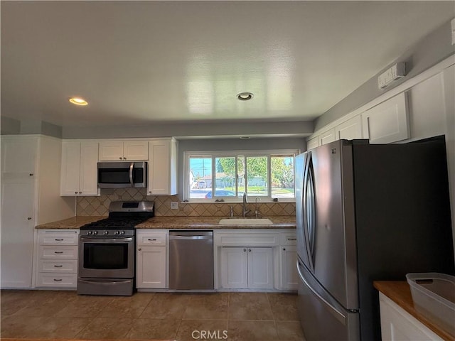 4561 Mimosa Dr, Yorba Linda, CA 92886 - kitchen featuring appliances with stainless steel finishes, white cabinets, backsplash, stone countertops, and light tile patterned flooring