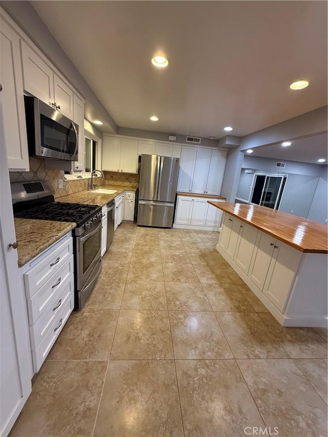 4561 Mimosa Dr, Yorba Linda, CA 92886 - kitchen featuring stainless steel appliances, wooden counters, white cabinets, tasteful backsplash, and recessed lighting