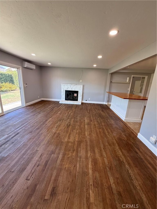 4561 Mimosa Dr, Yorba Linda, CA 92886 - unfurnished living room featuring dark wood-type flooring, a wall mounted AC, a fireplace, recessed lighting, and a textured ceiling