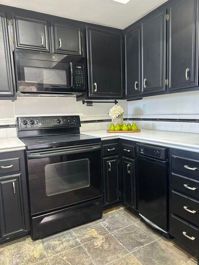 3998 Nobel Dr Unit 302, San Diego, CA 92122 - kitchen featuring black appliances, dark cabinetry, stone finish floors, and light countertops