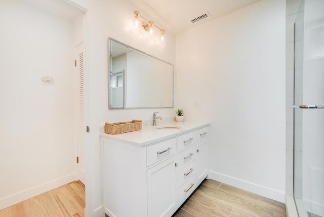 231 5th St, Encinitas, CA 92024 - bathroom with vanity, wood finished floors, and a closet