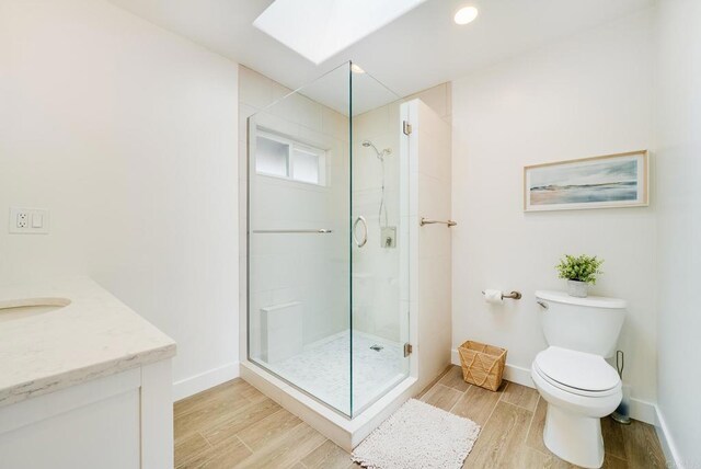 231 5th St, Encinitas, CA 92024 - bathroom featuring wood finished floors, vanity, a shower stall, and a skylight