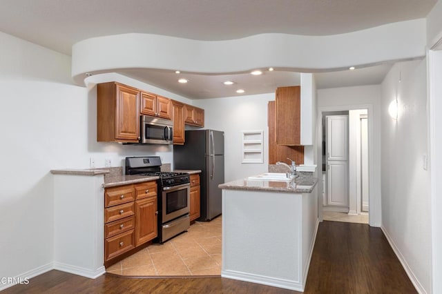 365 Burchett St Unit 112, Glendale, CA 91203 - kitchen featuring stainless steel appliances, brown cabinets, recessed lighting, a peninsula, and light wood-type flooring