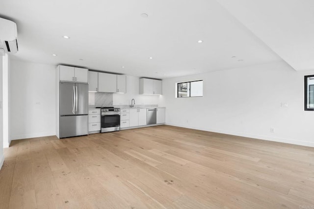 2052 Montgomery Ave, Cardiff By The Sea, CA 92007 - kitchen featuring stainless steel appliances, light wood-style floors, white cabinetry, a wall unit AC, and light countertops