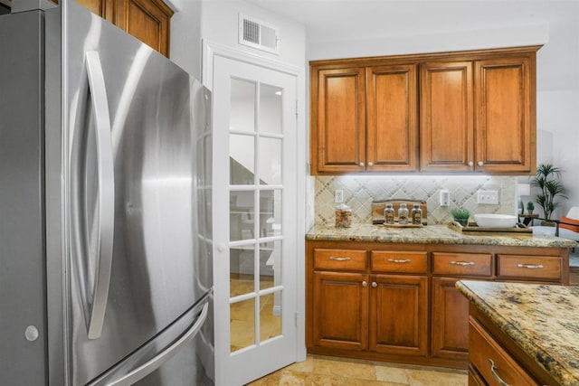 915 Lake Ridge Dr, San Marcos, CA 92078 - kitchen featuring freestanding refrigerator, brown cabinets, decorative backsplash, and light stone counters