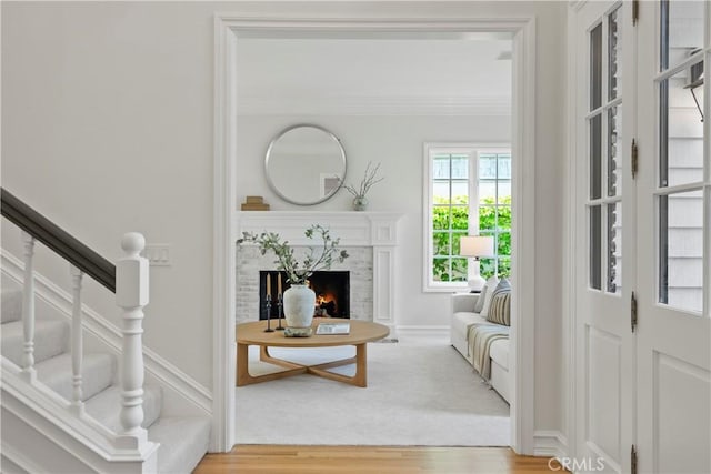 7 Belmont, Newport Beach, CA 92660 - living room featuring wood finished floors, a warm lit fireplace, crown molding, and stairs