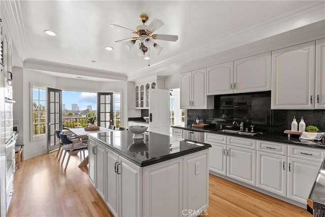 7 Belmont, Newport Beach, CA 92660 - kitchen featuring ceiling fan, white cabinets, a kitchen island, tasteful backsplash, and ornamental molding