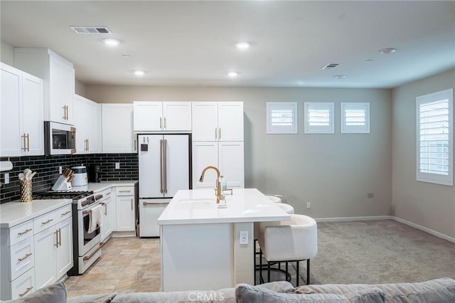 4098 Summer Way, Corona, CA 92883 - kitchen with stainless steel appliances, a kitchen breakfast bar, a kitchen island with sink, white cabinetry, and tasteful backsplash
