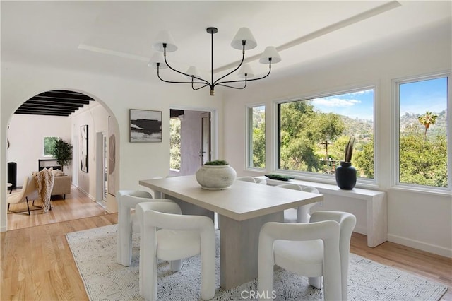 2982 Edgewick Rd, Glendale, CA 91206 - dining area with arched walkways, a chandelier, healthy amount of natural light, and light wood finished floors