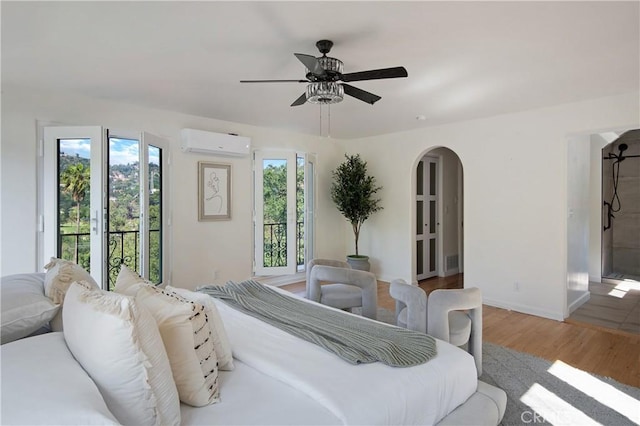 2982 Edgewick Rd, Glendale, CA 91206 - bedroom featuring a wall mounted AC, access to outside, arched walkways, wood finished floors, and ceiling fan