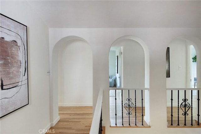 2982 Edgewick Rd, Glendale, CA 91206 - hallway featuring arched walkways, wood finished floors, and an upstairs landing