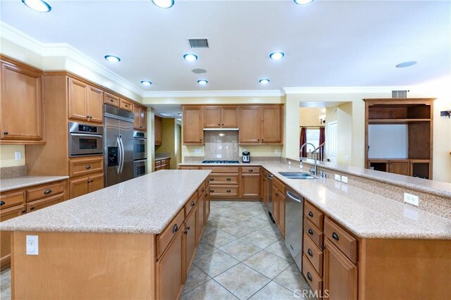 14145 Prairie Creek Pl, Eastvale, CA 92880 - kitchen featuring appliances with stainless steel finishes, a center island, tasteful backsplash, light stone counters, and ornamental molding