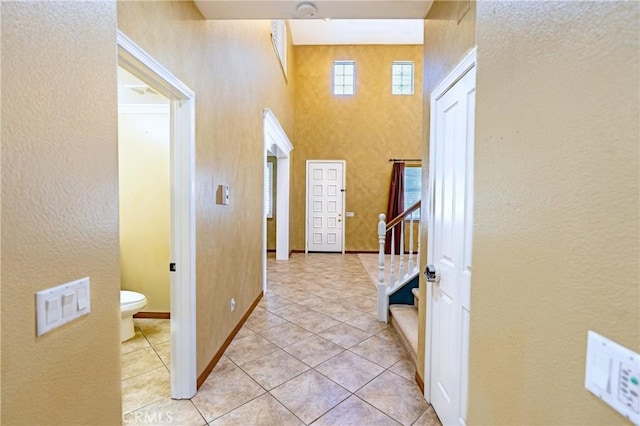 14145 Prairie Creek Pl, Eastvale, CA 92880 - entrance foyer featuring stairway, light tile patterned floors, a textured wall, and a towering ceiling