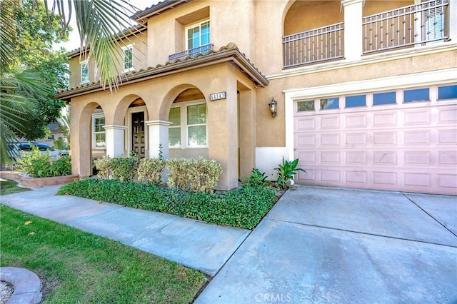 14145 Prairie Creek Pl, Eastvale, CA 92880 - property entrance with stucco siding, an attached garage, concrete driveway, and a balcony