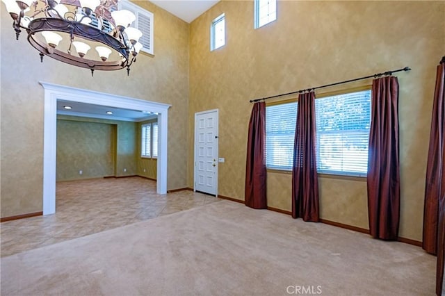 14145 Prairie Creek Pl, Eastvale, CA 92880 - unfurnished living room featuring healthy amount of natural light, a chandelier, carpet flooring, and a high ceiling