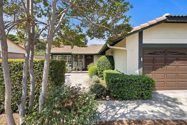 6807 Wilding Pl, Riverside, CA 92506 - ranch-style house with an attached garage, a tile roof, and stucco siding