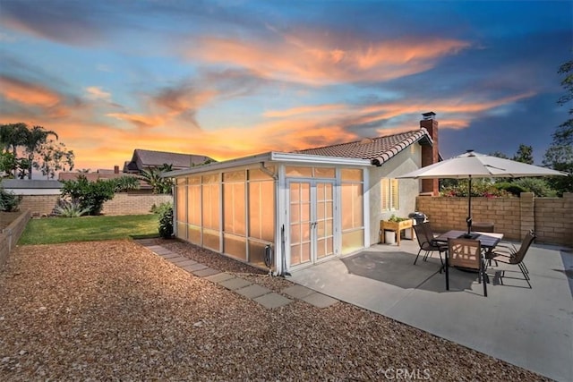 6807 Wilding Pl, Riverside, CA 92506 - back of property with a sunroom, a chimney, a patio, a fenced backyard, and a tiled roof
