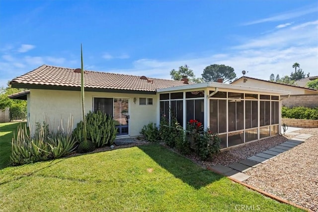 6807 Wilding Pl, Riverside, CA 92506 - rear view of house with stucco siding, a sunroom, a yard, and a tile roof