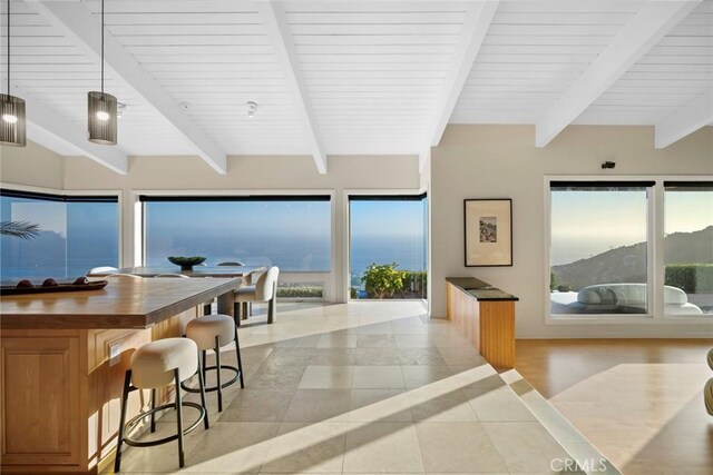 32131 Sea Island Dr, Dana Point, CA 92629 - kitchen with light tile patterned flooring, beamed ceiling, a breakfast bar, healthy amount of natural light, and wood counters