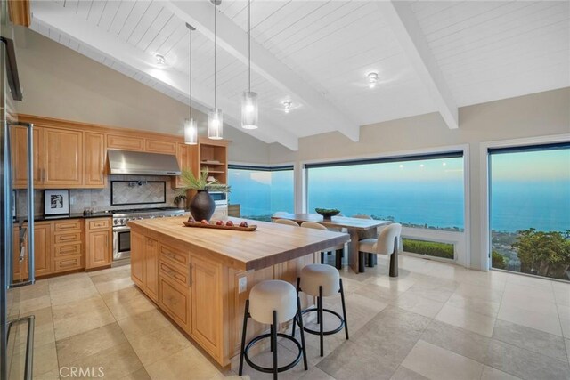 32131 Sea Island Dr, Dana Point, CA 92629 - kitchen featuring butcher block counters, high end stainless steel range oven, under cabinet range hood, a kitchen bar, and backsplash