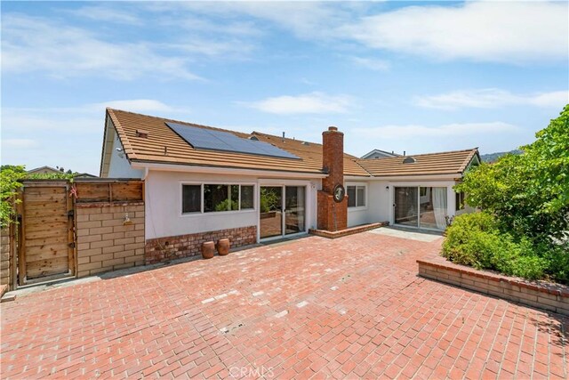 1707 Gay Park Way, Hacienda Heights, CA 91745 - back of property featuring solar panels, a patio, a chimney, a gate, and stucco siding