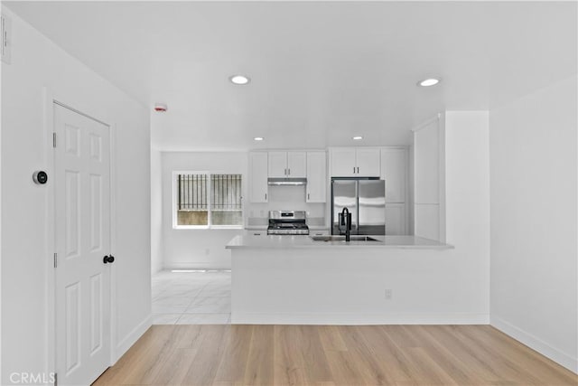 9019 Cedros Ave Unit 2, Panorama City, CA 91402 - kitchen with stainless steel appliances, white cabinetry, under cabinet range hood, light countertops, and recessed lighting