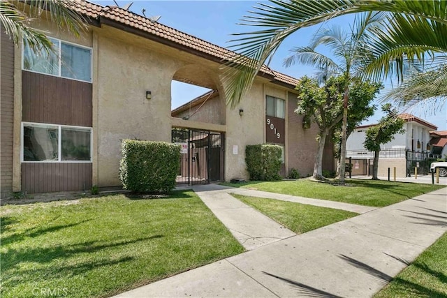 9019 Cedros Ave Unit 2, Panorama City, CA 91402 - view of front facade with stucco siding, a front lawn, a gate, and a tile roof