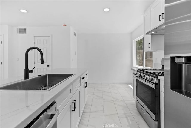 9019 Cedros Ave Unit 2, Panorama City, CA 91402 - kitchen with stainless steel appliances, under cabinet range hood, light marble finish floors, recessed lighting, and white cabinetry