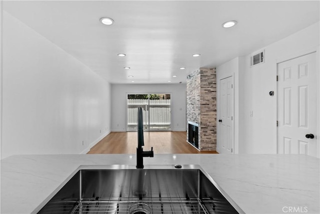 9019 Cedros Ave Unit 2, Panorama City, CA 91402 - kitchen featuring wood finished floors, light stone countertops, recessed lighting, and a fireplace