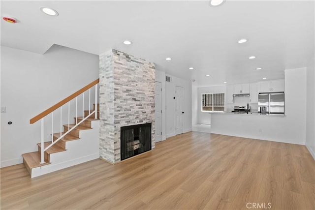 9019 Cedros Ave Unit 2, Panorama City, CA 91402 - unfurnished living room featuring stairway, light wood finished floors, recessed lighting, and a stone fireplace