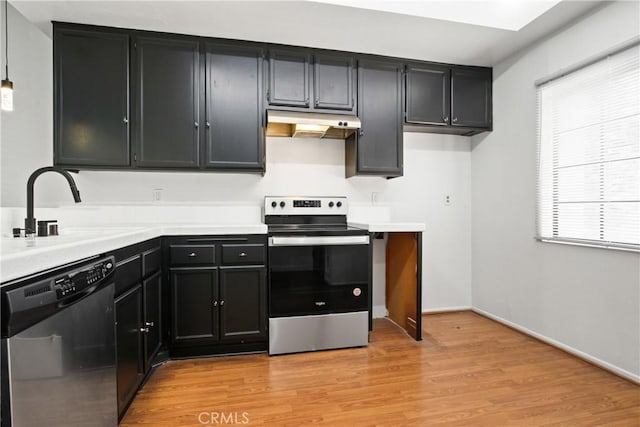 941 W Carson St Unit 210, Torrance, CA 90502 - kitchen with stainless steel appliances, under cabinet range hood, light countertops, dark cabinetry, and light wood-style floors