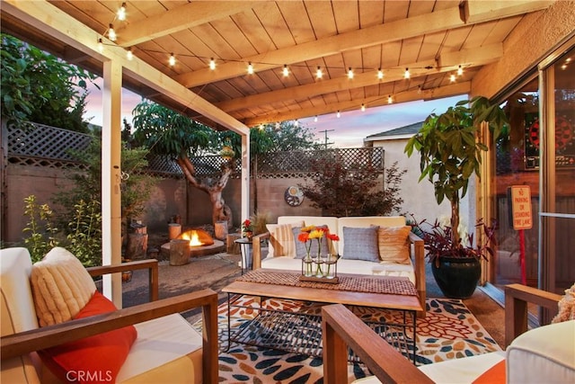 2283 Ximeno Ave, Long Beach, CA 90815 - patio terrace at dusk featuring an outdoor living space with a fire pit, a fenced backyard, and a patio area