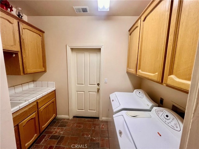 21509 Stage Dr, Tehachapi, CA 93561 - laundry area with cabinet space, separate washer and dryer, and brick patterned flooring