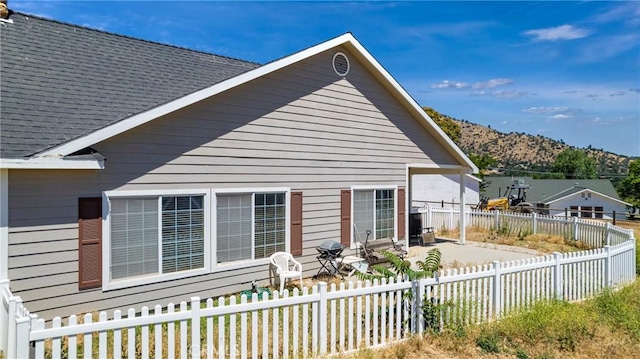 21509 Stage Dr, Tehachapi, CA 93561 - view of side of home featuring a patio area, a mountain view, roof with shingles, and a fenced backyard